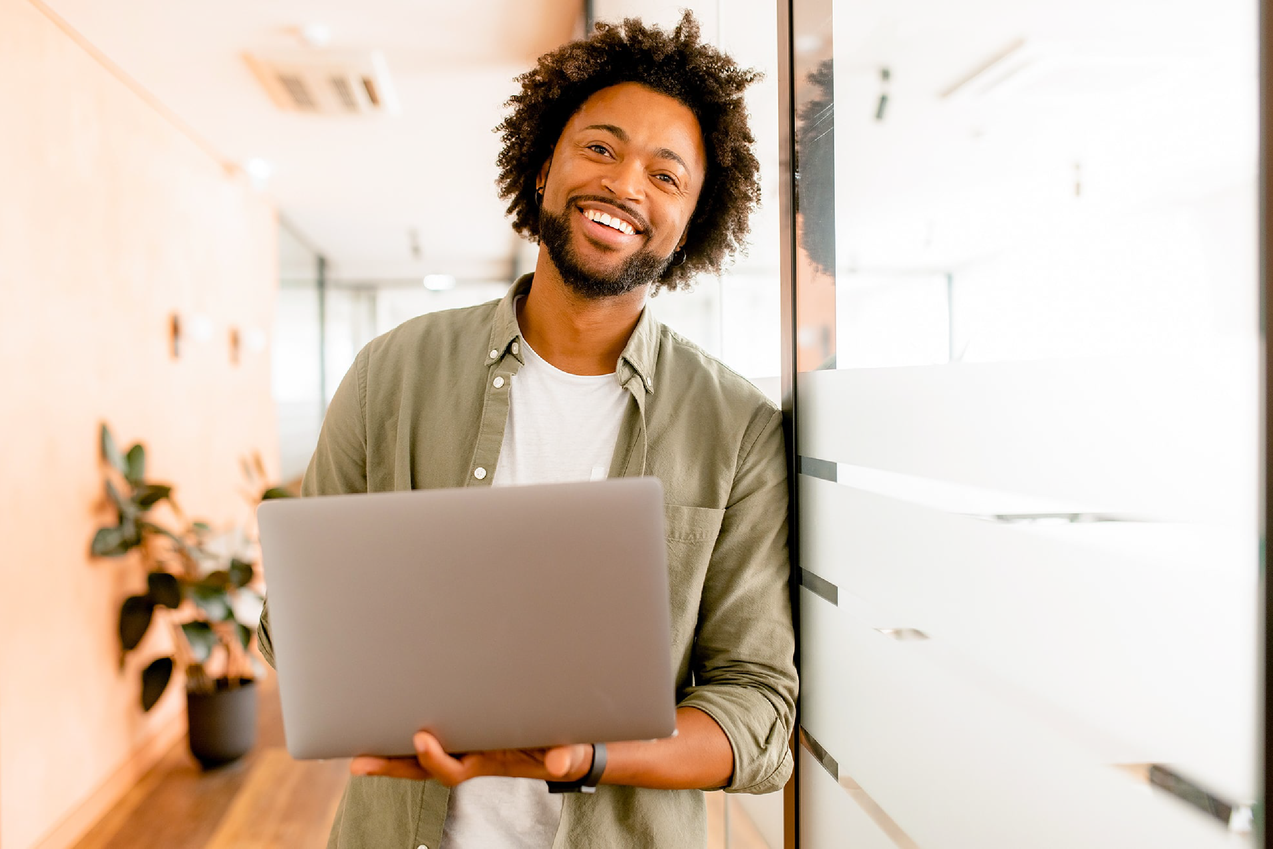 man holding a laptop smiling