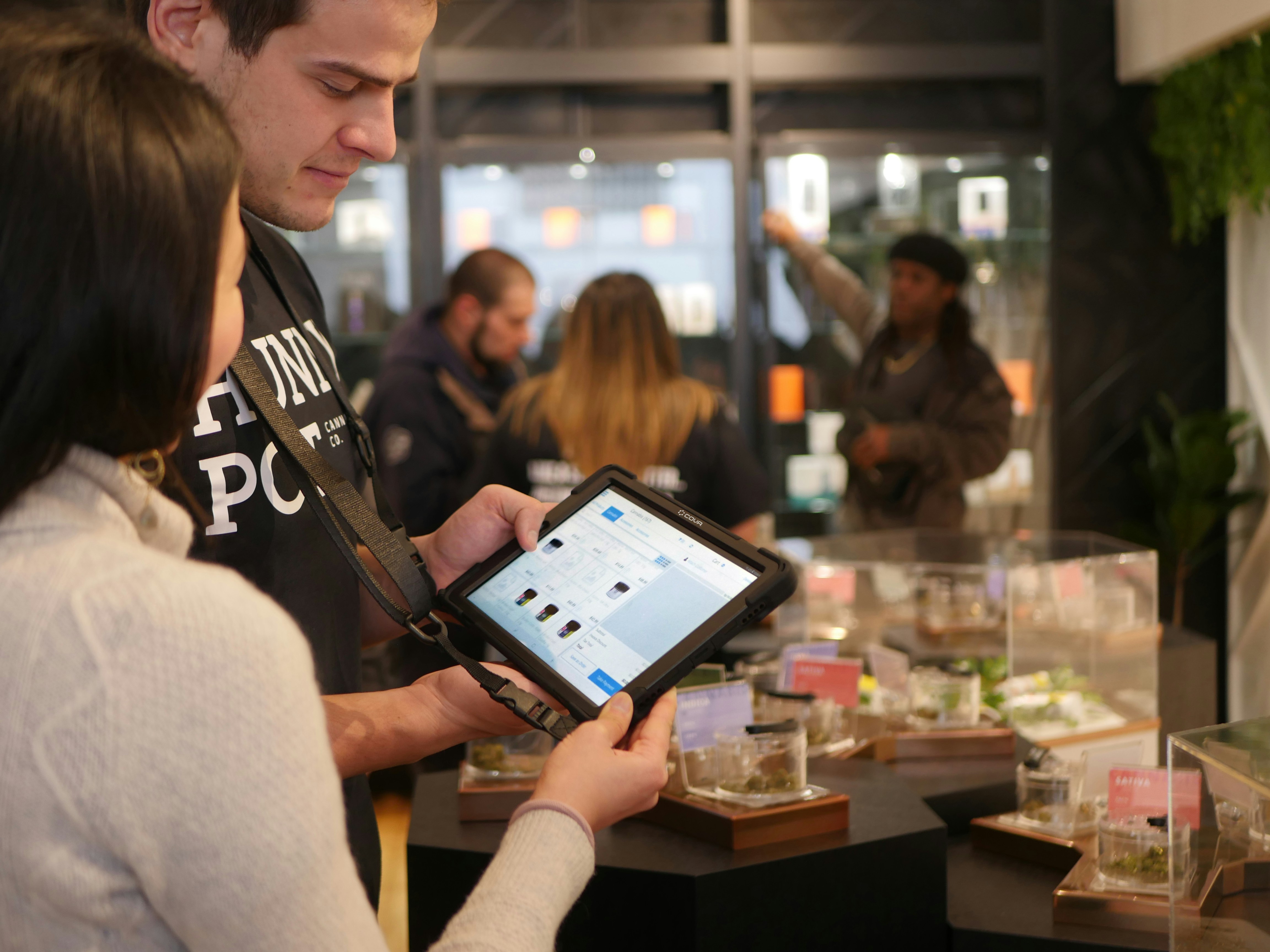 salesperson showing products to a customer on a tablet