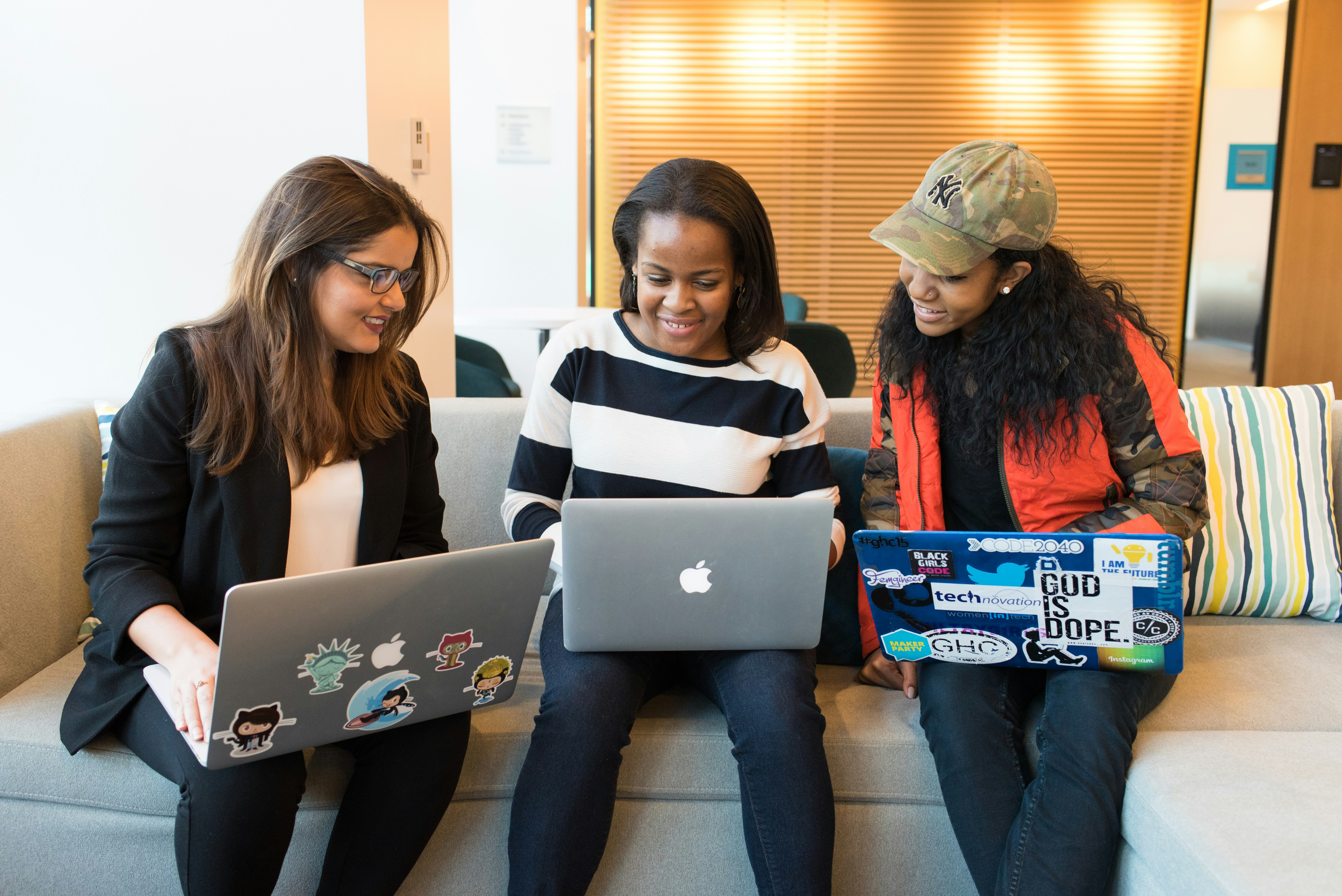 women smiling at their laptops